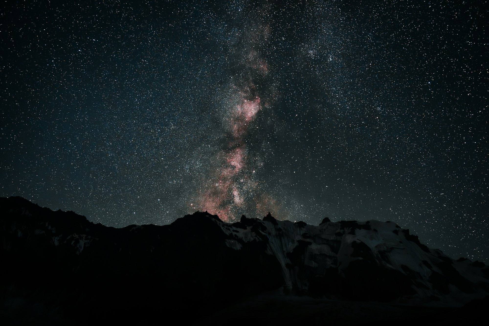 The Milky Way rising over a dark mountain ridge