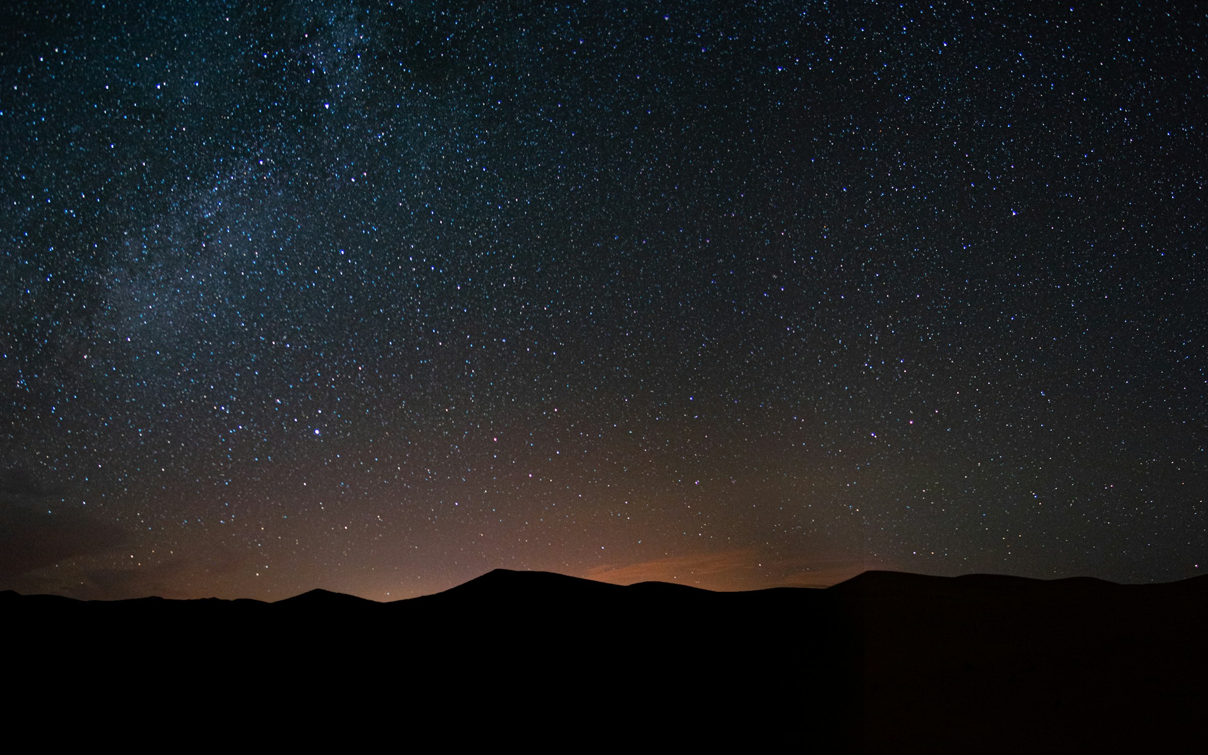 A black desert ridge under a dense field of stars